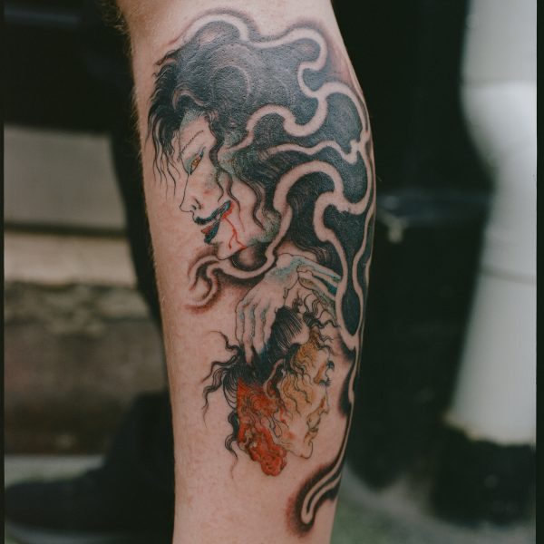 Calf tattooed with a traditional Japanese style ghost of a woman holding a severed head (namakubi). This custom tattoo design was by Harriet Street, based in Brighton, UK at Nowhere Tattooing