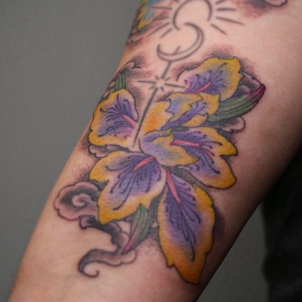 Bright and colorful, botanical tattoo of an Iris. Tattooed in a fine line Japanese style by Harriet Street, based at Nowhere Tattoo in Brighton, UK.