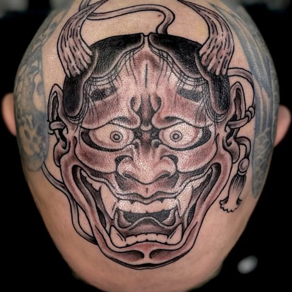 Top of a clients head, tattooed with the a traditional Japanese demon mask. This Hanna mask was tattooed in Brighton, UK by Antony Dickinson, northernbuilt at Nowhere Tattooing