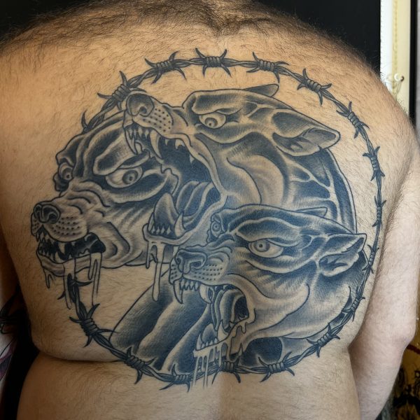 Pictured is a well healed and settled backpiece, drawn freehand on the skin and tattoo in a western traditional, black work style at Nowhere Tattooing in Brighton, UK