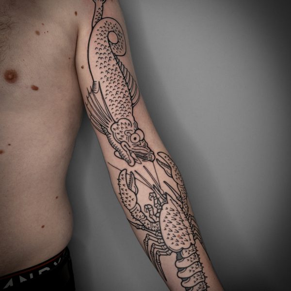 Mouse is an artist based at Nowhere Tattoo Shop in Brighton, East Sussex. Mouse has built a reputation by creating fanciful, and quirky tattoos, often depicting off-beat subjects, such as, frogs dancing around a fire, men with berries on their heads, hands appearing from clouds, and rabbits riding snails.